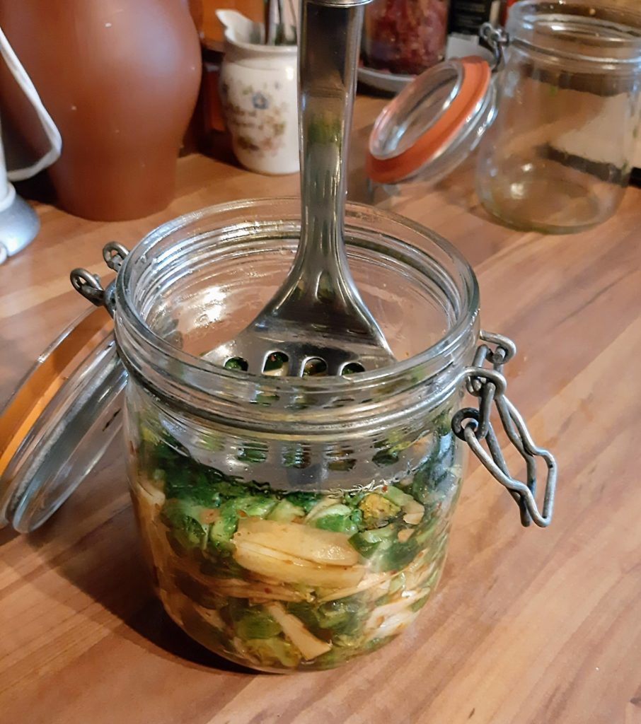 Rosenkohlkimchi ins Glas einstampfen